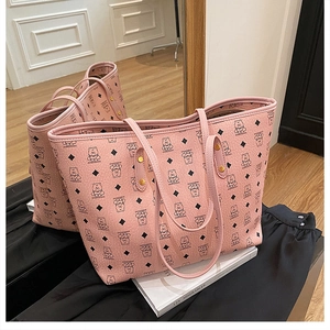 Detail of pink tote bag with bear print pattern, side rivets, and mirrored reflection