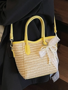 Contrast straw bucket bag with yellow leather handles and white lace bow decoration