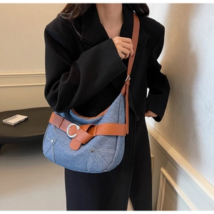 Détail du sac à bandoulière en denim vintage avec lanière en cuir et boucle en C argentée