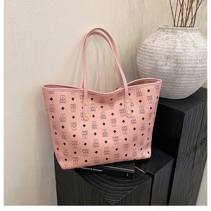 Macro detail of a pale pink tote bag featuring black cartoon bear prints and gold rivets
