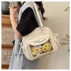 Detail der cremeweißen Ita-Bag mit transparentem Fenster und Glücksstern-Lederdekor