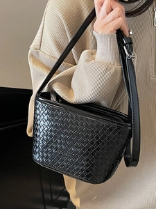 Sac seau noir minimaliste à texture tressée avec bandoulière et logo mode embossé