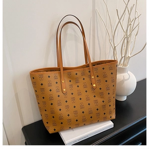 Close-up of brown tote bag featuring teddy bear print and premium synthetic leather texture