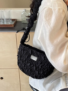 Fashionable black pleated cloud bag with textured fabric and metallic logo detail