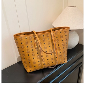 Detailed macro view of large tote bag with bear print and caramel lychee leather texture