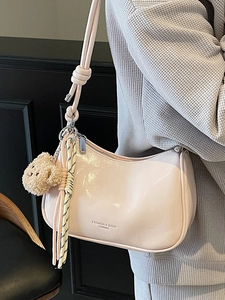 Minimalist beige glossy shoulder bag with cute bear charm and striped ribbon detail