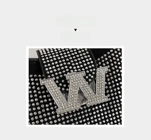 Detailed view of black rhinestone handbag featuring a sparkling crystal-encrusted metal W buckle