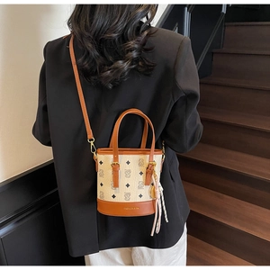 Detailed view of canvas bucket bag with brown leather trim and bear pattern print