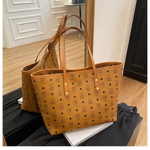 Detail of classic brown monogram tote bag with sturdy leather handles and rivet accents