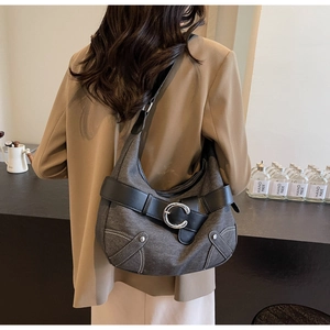 Détail de la boucle métallique argentée C et des coutures contrastées du sac hobo gris