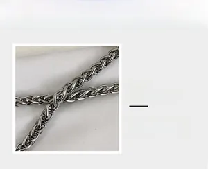 Detail view of woven metal chain strap with dark silver hardware and metallic texture