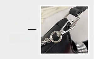 Detail magnification of silver metal clasp and sparkling rhinestones on black crossbody bag