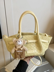Lemon yellow woven handbag with a teddy bear charm and adjustable shoulder strap