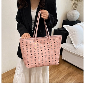 Detail view of large pink tote bag with cartoon bear pattern and reinforced metal rivets