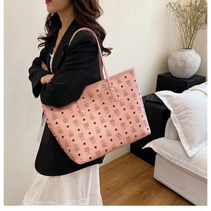 Close-up of pink tote bag featuring bear patterns and golden rivet metal details