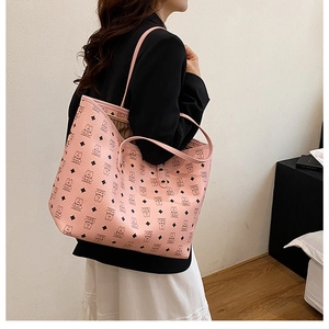Pink tote bag with classic bear pattern shown on model in a stylish office setting