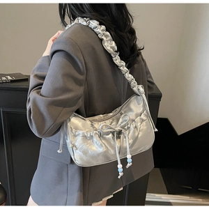 Detail of silver metallic pleated shoulder bag with bow and colorful beaded drawstring