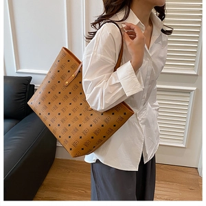 Classic cognac tote bag with black geometric pattern detail shown on a model