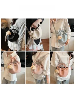 Détail du sac seau avec pendentif chiot mignon et bandoulières réglables