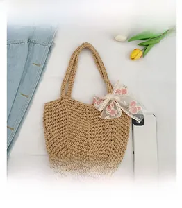 Detail of beige woven tote bag with pink floral lace bow and textured V-pattern knit