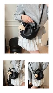 Détail du sac seau en cuir grainé noir avec un joli charme de chien en peluche