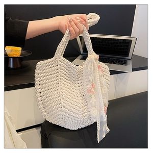 Detail of white woven tote bag featuring floral lace ribbon and thick handmade texture