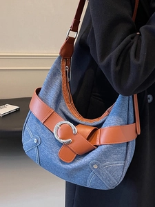 Sac cabas rétro en jean avec finitions en cuir marron et boucle argentée sur un mannequin