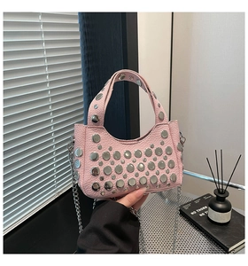 Dettaglio della borsa a secchiello rosa con borchie in metallo e trama litchi