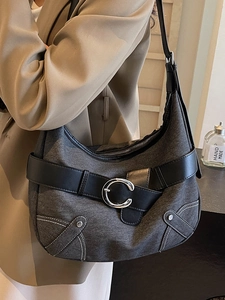Sac fourre-tout en denim gris foncé avec ceinture en cuir et boucle argentée sur modèle