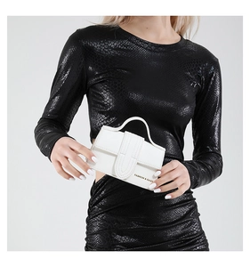 Detail of white mini handbag with pebble leather texture and gold logo print
