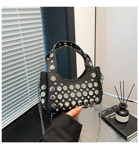 Dettaglio della borsa a secchiello punk nera con borchie argentate e grana litchi