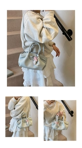 Detail view of light blue pleated bucket bag with lychee texture and doll charm