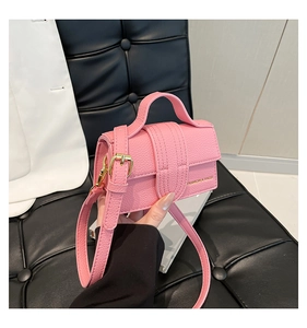 Detailed close-up of pink litchi grain leather mini bag with gold hardware and strap