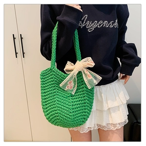 Detailed close-up of vibrant green woven tote bag with floral lace bow accessory