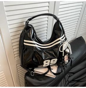 Gros plan du sac à bandoulière Y2K noir brillant avec patch 89 blanc et chaîne de perles