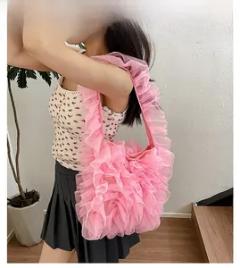 Close-up of pink layered mesh pleated tote bag with romantic ruffle texture on shoulder strap