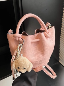 Sac seau rose en cuir grainé avec pendentif nounours et poignée élégante nouée