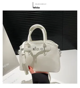 Detail of a white luxury leather tote bag showing a sleek belt buckle and detachable strap