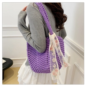 Detail of purple woven tote bag featuring white lace scarf with pink rose floral embroidery