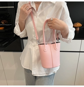 Sakura pink bucket bag with lychee grain texture and detachable shoulder strap on model
