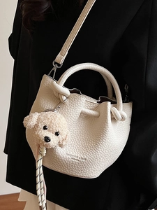 Sac seau blanc à motif litchi avec breloque peluche et bandoulière tissée chic