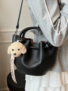 Sac seau minimaliste noir à motif litchi avec pendentif chien en peluche et bandoulière