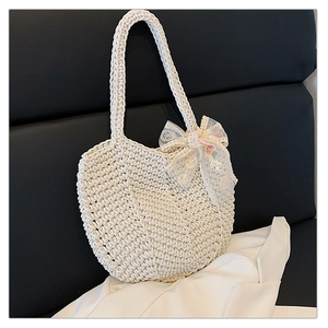 Detail of hand-woven crochet tote bag featuring delicate lace bow and floral embroidery