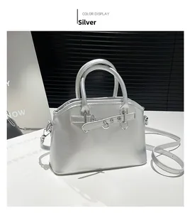 Detail view of the silver shell bag showing metallic texture and adjustable shoulder strap