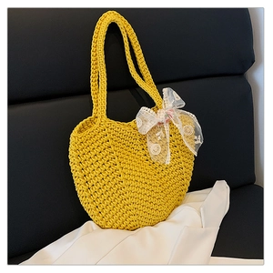 Detail of yellow hand-woven crochet tote bag featuring a delicate lace flower bow