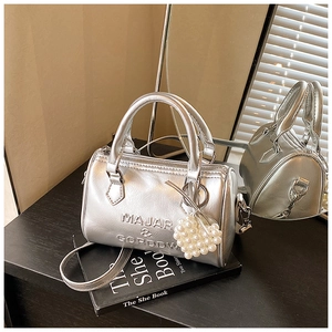 Dettaglio borsa Boston argento metallizzato con lettere sbalzate e ciondolo a cuore