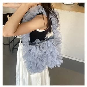 Detail of greyish blue layered ruffles and soft mesh fabric on this chic tote bag