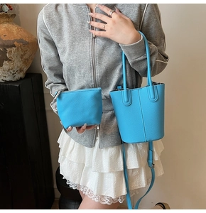 Close-up of vibrant blue bucket bag and matching pouch with lychee texture
