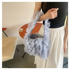 Detailed view of light blue ruffled lace tote bag with silver magnetic snap closure