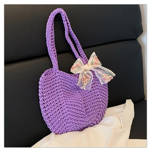 Close-up of handmade purple woven tote bag featuring floral lace bow and textured knit